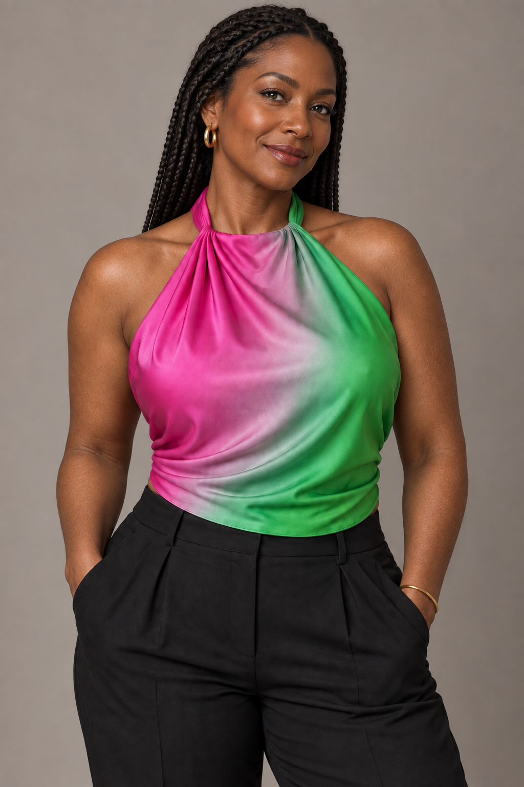 Woman with long braids wearing the Radiant Oasis pink and green ombré silk scarf as a halter top with black trousers.